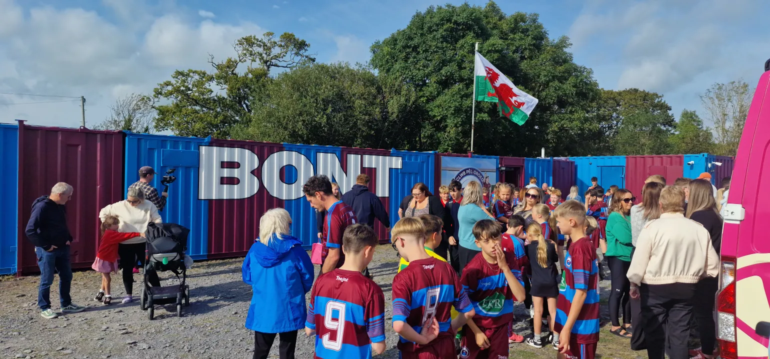 An update on a recent collaboration with the Welsh TV programme, Prosiect Pum Mil (Five Thousand Pound Project).
This TV show is focused on undertaking various community projects across local areas, all while adhering to a strict £5,000 budget.
Their most recent project was with a local football team, CPD Bontnewydd FC, who wanted to build a stand in memory of a former player, Josh Lloyd Roberts, who tragically passed away in an accident in 2023. The football club wanted to create a lasting tribute, and we worked closely with Prosiect Pum Mil to ensure the project was completed within the budget while honouring the player’s legacy.
BM Steel contributed to the project by providing the steelwork for the frame, the concrete mesh used in the groundworks, and the GRP floor sheets and nosings for the stand flooring.
The episode featuring this project is due to air on S4C in May 2025.